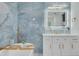 Elegant bathroom with custom blue tiling, soaking tub, white vanity, and tasteful brass fixtures and accents at 11296 115Th St, Largo, FL 33778