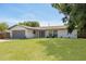 Beautiful single-story home with a well-manicured lawn, grey trim and a two-car garage on a sunny day at 11296 115Th St, Largo, FL 33778