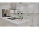 Gourmet kitchen featuring white cabinets, marble countertops, a modern range hood and stainless steel appliances at 11296 115Th St, Largo, FL 33778