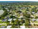 Expansive aerial view showcasing the neighborhood, mature trees, and a home with a sparkling private pool at 1235 Nelson St, Dunedin, FL 34698