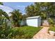 Well-maintained backyard features a shed and lush landscaping, offering privacy at 1235 Nelson St, Dunedin, FL 34698