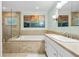Bathroom featuring a tub, shower, vanity and tile floors, with natural light and decorative artwork at 1235 Nelson St, Dunedin, FL 34698