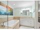 Bright bathroom featuring a soaking tub, decorative tile accents, and a vanity with great storage at 1235 Nelson St, Dunedin, FL 34698