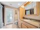 Bathroom with a wooden vanity, large mirror, and walk-in shower, illuminated by natural light at 1235 Nelson St, Dunedin, FL 34698