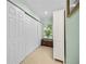 Hallway with large white closet space, neutral tile flooring, and view to the outside from a window at 1235 Nelson St, Dunedin, FL 34698