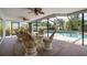 Cozy lanai with comfortable seating and ceiling fans overlooks the beautiful backyard and pool at 1235 Nelson St, Dunedin, FL 34698