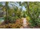 Lush tropical landscaping featuring a brick path that winds through the beautiful backyard at 1235 Nelson St, Dunedin, FL 34698