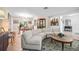 Open-concept living area featuring a stylish curved sofa, display case, and access to the dining area at 1235 Nelson St, Dunedin, FL 34698