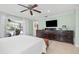 Bright bedroom with tiled floors, a ceiling fan, backyard access, and an expansive dresser at 1235 Nelson St, Dunedin, FL 34698