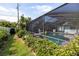 Enjoy the beautiful outdoor living space from the pool that's bordered by tropical landscaping at 1235 Nelson St, Dunedin, FL 34698