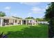 Expansive backyard featuring a covered patio, lush lawn, and privacy fence, ideal for outdoor enjoyment at 1247 Overcash Dr, Dunedin, FL 34698