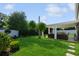 Landscaped backyard featuring a covered patio, lush lawn, and privacy fence, ideal for outdoor enjoyment at 1247 Overcash Dr, Dunedin, FL 34698