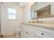Bright bathroom featuring a modern vanity with white cabinetry, a large mirror, and a window for natural light at 1247 Overcash Dr, Dunedin, FL 34698