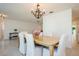 Dining room view featuring a wooden table, white chairs, and contemporary chandelier at 1247 Overcash Dr, Dunedin, FL 34698