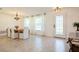 Bright dining room featuring an elegant chandelier, a wooden table, and white chairs at 1247 Overcash Dr, Dunedin, FL 34698