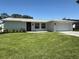 Charming single-story home with a well-manicured lawn and a cozy, inviting exterior at 1247 Overcash Dr, Dunedin, FL 34698