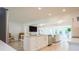 Well-lit kitchen with white cabinets, stainless-steel appliances, island seating, and open living area at 1247 Overcash Dr, Dunedin, FL 34698