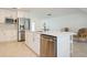 Bright kitchen featuring a stainless steel dishwasher and fridge, white countertops, and ample storage space at 1247 Overcash Dr, Dunedin, FL 34698