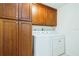 Functional laundry room featuring wood cabinets and modern washer and dryer at 1247 Overcash Dr, Dunedin, FL 34698