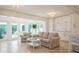 Bright, open living room with tiled floors, neutral furniture, and glass doors to the backyard at 1247 Overcash Dr, Dunedin, FL 34698