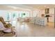 Bright, open living space with tile floors, seamlessly flowing into the modern kitchen with a large island at 1247 Overcash Dr, Dunedin, FL 34698
