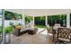 Inviting covered patio with comfortable seating, dining area, and lush green views, perfect for relaxation and entertaining at 1247 Overcash Dr, Dunedin, FL 34698