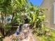 Path to backyard is lined with lush landscaping and flowers leading to a covered porch at 1330 Belcher Dr, Tarpon Springs, FL 34689