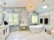 Luxurious bathroom featuring a soaking tub, marble floors and elegant lighting fixture at 1330 Belcher Dr, Tarpon Springs, FL 34689