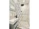 Bathroom with a modern shower, marble tiling, and a mounted sink at 1330 Belcher Dr, Tarpon Springs, FL 34689