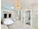 Bright bathroom featuring glass enclosed shower, soaking tub and elegant light fixtures at 1330 Belcher Dr, Tarpon Springs, FL 34689