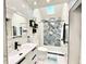 Modern bathroom with walk-in shower featuring stone-look accent wall and skylight at 1330 Belcher Dr, Tarpon Springs, FL 34689