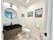 Modern half-bathroom with a black sink, stylish mirror, and contemporary decor at 1330 Belcher Dr, Tarpon Springs, FL 34689