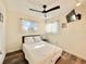 Cozy bedroom featuring two windows, a ceiling fan, and wood-look flooring at 1330 Belcher Dr, Tarpon Springs, FL 34689