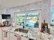 Kitchen featuring a decorative backsplash, stainless steel sink and a view to the pool at 1330 Belcher Dr, Tarpon Springs, FL 34689