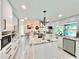 Bright eat-in kitchen with granite counters, stainless steel appliances, central island, and modern lighting fixtures at 1330 Belcher Dr, Tarpon Springs, FL 34689