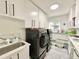 Laundry room with modern washer and dryer, sink, and storage at 1330 Belcher Dr, Tarpon Springs, FL 34689