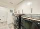 Laundry room with modern washer and dryer, sink, and storage at 1330 Belcher Dr, Tarpon Springs, FL 34689