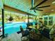 Inviting outdoor patio with wood ceilings, ceiling fans, dining table and view of the pool at 1330 Belcher Dr, Tarpon Springs, FL 34689