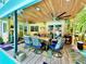 Inviting outdoor patio with wood ceilings, ceiling fans, dining table and view of lush greenery at 1330 Belcher Dr, Tarpon Springs, FL 34689