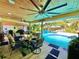 Inviting outdoor patio with wood ceilings, ceiling fans, dining table and view of the pool at 1330 Belcher Dr, Tarpon Springs, FL 34689