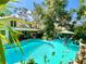 Aerial view of backyard pool surrounded by lush landscaping and an outdoor seating area at 1330 Belcher Dr, Tarpon Springs, FL 34689