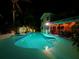 Inviting backyard pool and patio illuminated at night, ideal for relaxation and outdoor entertaining at 1330 Belcher Dr, Tarpon Springs, FL 34689