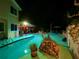 Backyard pool area featuring a covered patio, lush landscaping, and decorative stone, perfect for relaxation at 1330 Belcher Dr, Tarpon Springs, FL 34689