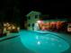 Inviting backyard pool illuminated at night, perfect for relaxation and entertaining with covered patio at 1330 Belcher Dr, Tarpon Springs, FL 34689