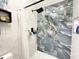 Walk-in shower features gray stone-look accent wall and modern fixtures at 1330 Belcher Dr, Tarpon Springs, FL 34689