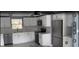 Modern kitchen with stainless steel appliances, white cabinets, and a window above the sink at 13314 Lisa Dr, Hudson, FL 34667