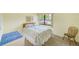 Carpeted bedroom with a comfortable bed and natural light from the window at 14130 Rosemary Ln # 4115, Largo, FL 33774