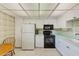 Efficient kitchen featuring white cabinets, black appliances, light countertops, and a cozy breakfast nook at 14130 Rosemary Ln # 4115, Largo, FL 33774