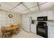 Functional kitchen area with white appliances, a cozy breakfast table, and ample cabinet space at 14130 Rosemary Ln # 4115, Largo, FL 33774