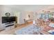 Spacious living room with a TV, ceiling fan, open to the dining area, with natural light and comfortable seating at 14130 Rosemary Ln # 4115, Largo, FL 33774